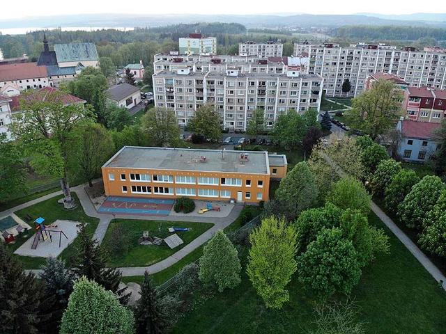 Letecký pohled na mateřskou školu a sídliště za parkem